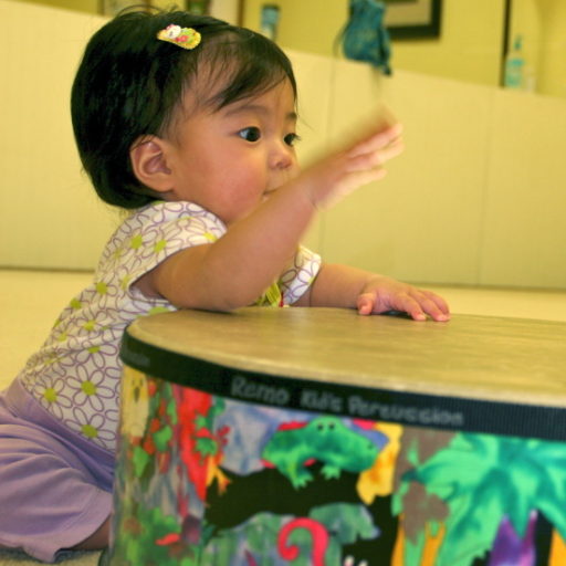 Baby drumming on a gathering drum