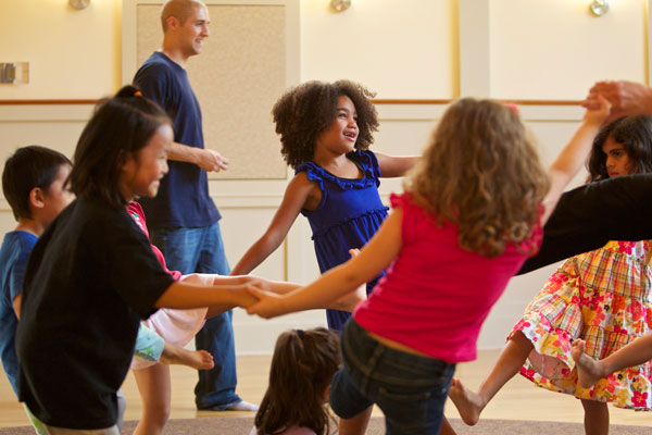 Children holding hands and dancing in a circle