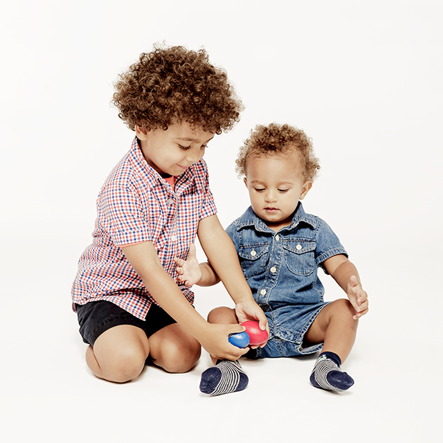 Siblings playing egg shakers together in Tam Tam's music class.