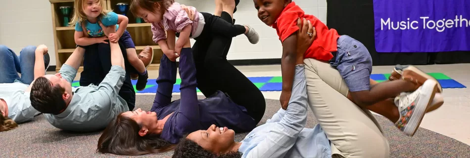 Parents lifting their babies in music class