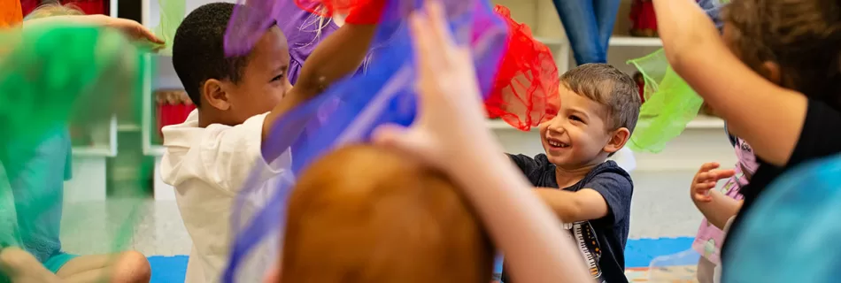 Preschoolers playing with scarves