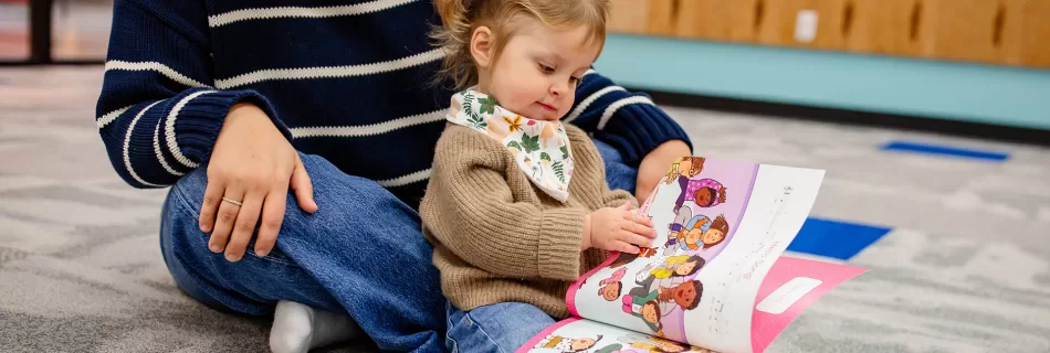 A preschooler singing through the songbook with her mom