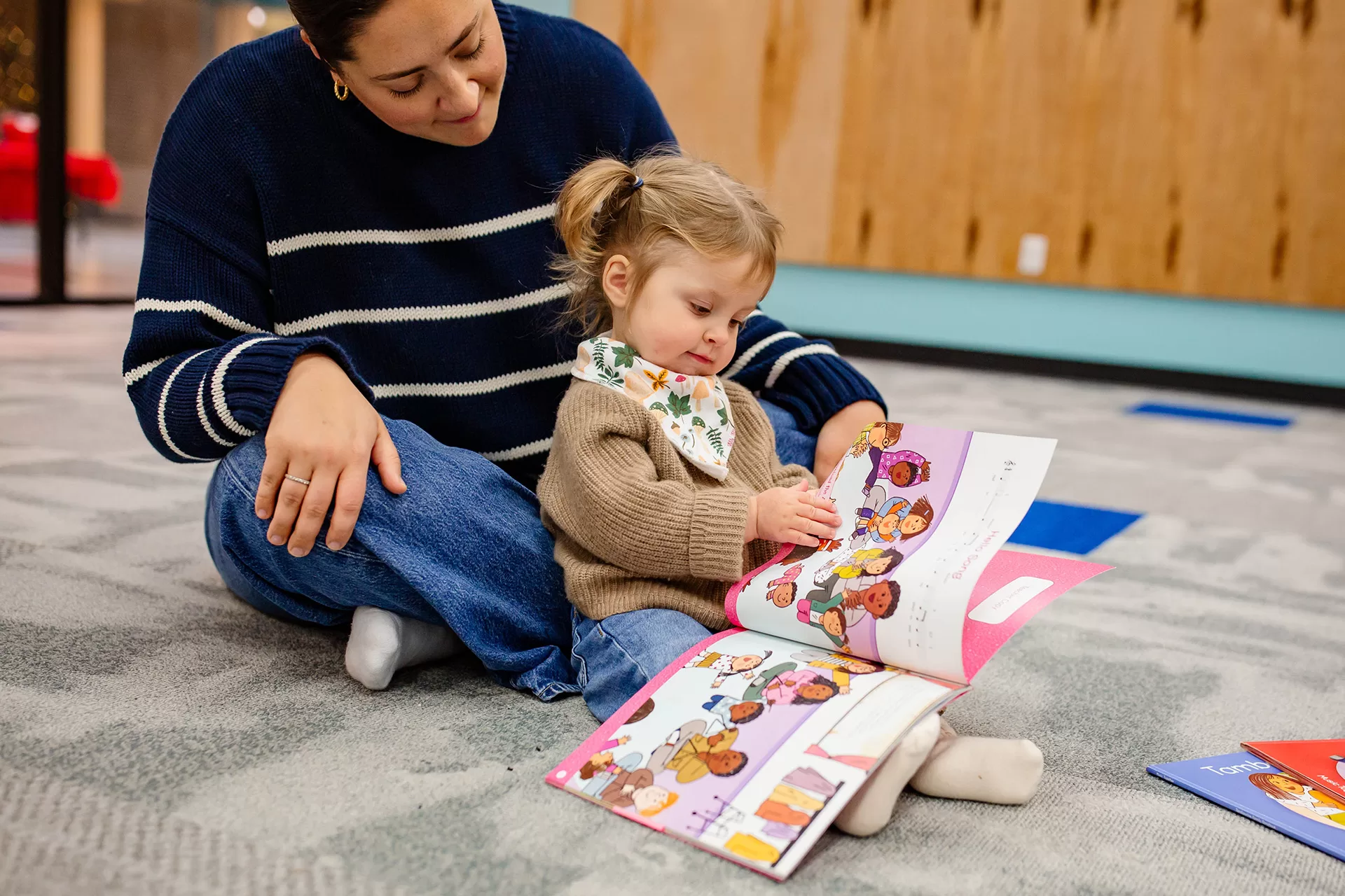 A preschooler singing through the songbook with her mom