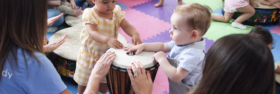 Children and adults drumming in Music Together class.