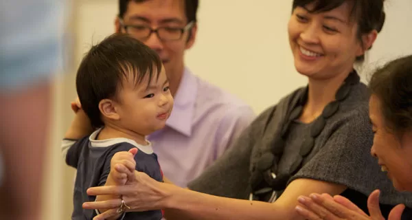 Parents and a toddler dancing together in Tam Tam's music class in Brooklyn.
